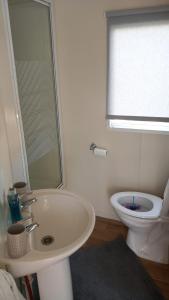a bathroom with a white sink and a toilet at Holiday Caravan in Clacton-on-Sea