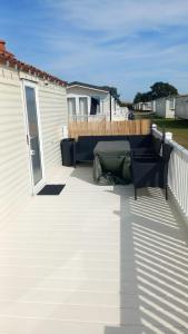 a deck with a bench on a house at Holiday Caravan in Clacton-on-Sea