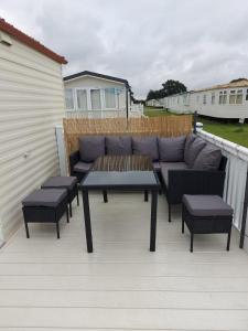 a patio with a couch and a table and chairs at Holiday Caravan in Clacton-on-Sea