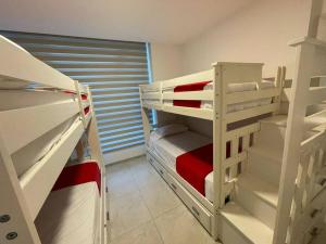 ein kleines Zimmer mit 2 Etagenbetten und einem Fenster in der Unterkunft Departamento en Tonsupa in Tonsupa