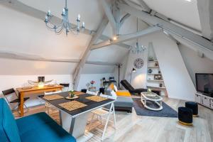 a living room with a table and a dining room at La Maison du Centre GOUVIEUX - CHANTILLY in Gouvieux