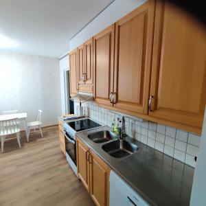 eine Küche mit Holzschränken und einem Waschbecken in der Unterkunft GREEN in Närpiö