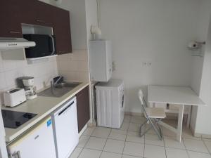 聖納澤爾的住宿－T2 proche Hôpital ouest，一间带水槽和冰箱的小厨房