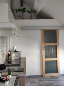 eine Küche mit einer Holztür in einem Zimmer in der Unterkunft L'escale CDG Astérix Park d'exposition in Louvres