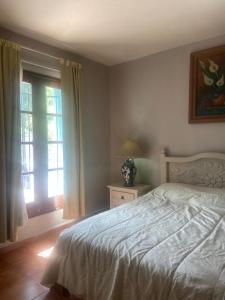 a bedroom with a white bed and a window at Hacienda Camelot in Cozumel