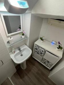 uma pequena casa de banho com um lavatório e um espelho em Mortella House em Nápoles