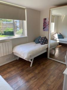 a small bedroom with a bed and a mirror at Spacious 2 Bed Elstree Borehamwood Hertfordshire in Elstree