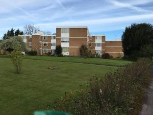 un gran edificio de apartamentos con un campo de césped en Spacious 2 Bed Elstree Borehamwood Hertfordshire en Elstree