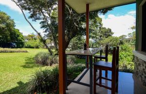 a table and chairs on a porch with a view of a yard at Yanu’s casita in Guaria