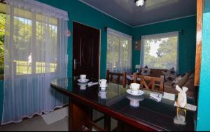 a blue room with a glass table and a couch at Yanu’s casita in Guaria +5 photos