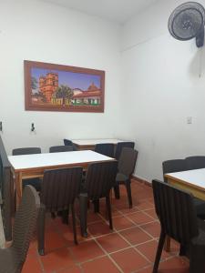 a dining room with tables and chairs and a painting on the wall at HOGAR DE PASO GUARACAO in Bucaramanga