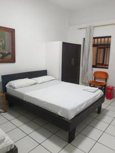 a bedroom with a bed and a chair at HOGAR DE PASO GUARACAO in Bucaramanga