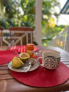 une table avec une assiette de nourriture et une tasse de café dans l'établissement Superbe Duplex résidence privée et piscine, à Saint-François