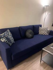 a blue couch in a living room with pillows on it at SylviaBo in Skien