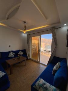 - un salon avec un canapé bleu et une table dans l'établissement Padova Surf House, à Imsouane