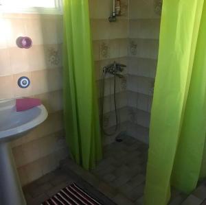 a bathroom with green shower curtains and a sink at FARE AHIATA MOOREA in Moorea