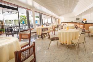 a dining room with tables and chairs and windows at Hotel Americas San Andres Islas Colombia in San Andrés