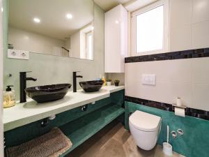 ein Badezimmer mit zwei Waschbecken und einer Toilette in der Unterkunft Villa Elena in Pineda de Mar + 4 Fotos