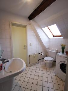 baño con lavabo y aseo y ventana en Schwert Apartment Verden, en Verden