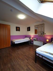 two beds in a room with purple walls and wooden floors at Schwert Apartment Verden in Verden