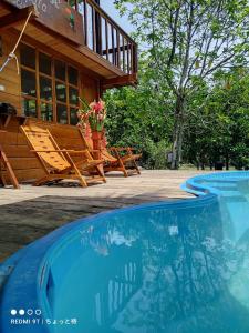 uma casa com um alpendre e uma piscina em CHOMI HOUSE TAMBOPATA em Puerto Maldonado