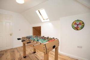 a foosball table in a room with a clock on the wall at LARGE CITY CENTRE PROPERTY in Derby