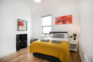 a bedroom with a bed with a yellow blanket at LARGE CITY CENTRE PROPERTY in Derby