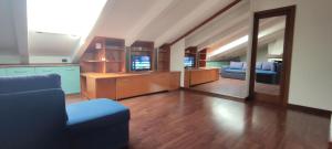 a living room with a blue couch and a television at Loft Mansardato in Monza