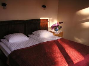 a bedroom with a bed with white sheets and a vase of flowers at Majoru Promenāde in Jūrmala