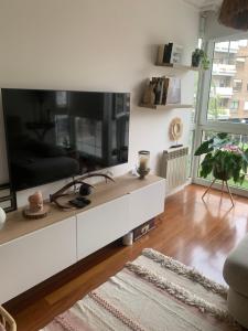 sala de estar con TV grande en un armario blanco en Precioso piso con garaje en el centro de Castro Urdiales, en Castro Urdiales