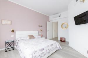 a white bedroom with a bed and a tv at Casa di Kiki in Finale Ligure