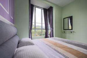sypialnia z łóżkiem i dużym oknem w obiekcie Moonight Luxe Suite, Cameron's Emerald Avenue w mieście Brinchang