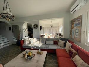 a living room with a couch and a red couch sidx sidx sidx at Villa Evridiki - Walking distance to beach in Porto Heli