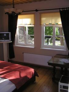 um quarto com 2 janelas, uma cama e uma mesa em Majoru Promenāde em Jūrmala