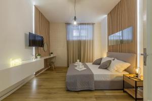 a bedroom with a large bed and a television at Imperium House - appartamento con giardino privato a 3 minuti da Metro Piazza Bologna in Rome