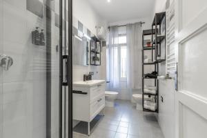 a white bathroom with a sink and a toilet at Imperium House - appartamento con giardino privato a 3 minuti da Metro Piazza Bologna in Rome