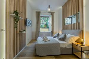 a bedroom with a large bed and a window at Imperium House - appartamento con giardino privato a 3 minuti da Metro Piazza Bologna in Rome
