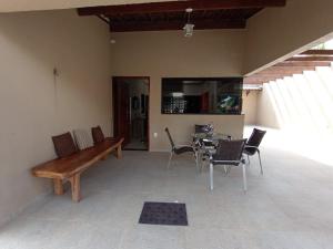 una sala de estar con un banco de madera y una mesa. en Casa MARAGOGI com PISCINA e área GOURMET COMPLETA, en Maragogi