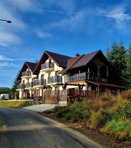 a large house on the side of a road at Willa "KomaNcza" Szczawnica E-Apartamenty in Szczawnica