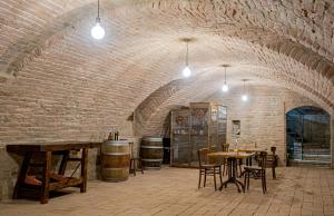 a room with tables and chairs and a brick wall at Fermo della Guazzona in Busseto