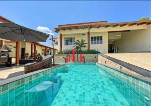 a swimming pool in front of a house at Linda Casa na EPTG com lazer completo - Brasília in Brasilia