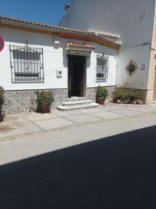 a white building with a door on a street at CASA SENDERO DEL RIO in El Bosque