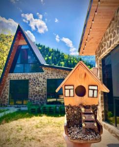 una pequeña casa de madera sentada frente a una casa en Cottage Orcs, en Borjomi