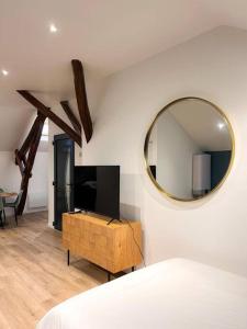 - une chambre avec un miroir et une télévision murale dans l'établissement Élégance et Cocooning Appartement pour 4 Choisy, à Choisy-le-Roi