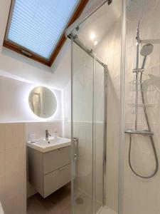 La salle de bains est pourvue d'une douche en verre et d'un lavabo. dans l'établissement Élégance et Cocooning Appartement pour 4 Choisy, à Choisy-le-Roi