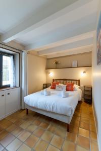 ein Schlafzimmer mit einem großen weißen Bett mit roten Kissen in der Unterkunft TY MELEN - Charmante maison bretonne proche mer in Plouguerneau