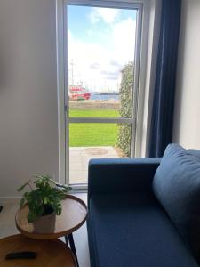 a living room with a blue couch and a window at Harbour Inn Hundested in Hundested