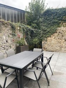 a wooden table and chairs on a patio at Au temps suspendu in Marche-en-Famenne