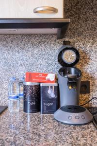 a counter top with a coffee maker and other ingredients at Tram station rooms by CityPillow since 2019 in Hesperange