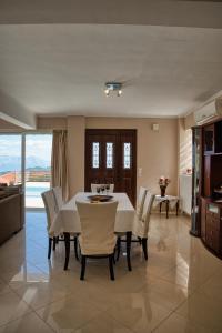 a dining room with a white table and chairs at Petronas Villa in Kariá